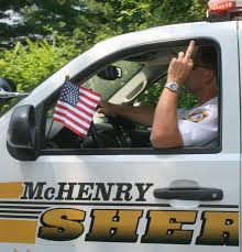 Undersheriff Andrew Zinke giving the finger at parade. 