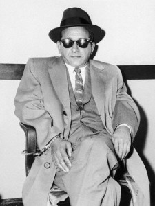 Sam "Mooney" Giancana is handcuffed to a chair